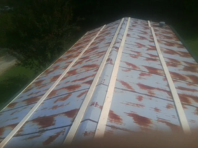 Rusted metal roof panels with new wood purlins before replacement — Storm Damage Roof Repair in Coshocton by Roofing Brothers