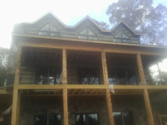 Dormers and porch framing on a large log home under construction — Roof Coating work by our crew in Coshocton