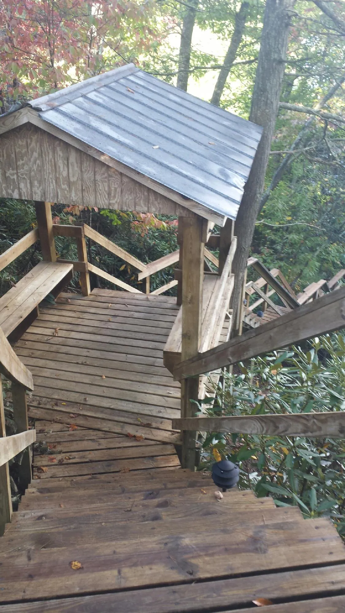 Metal roofed shelter over wooden steps on a wooded walkway — Skylight Repair & Installation work by our crew in Coshocton