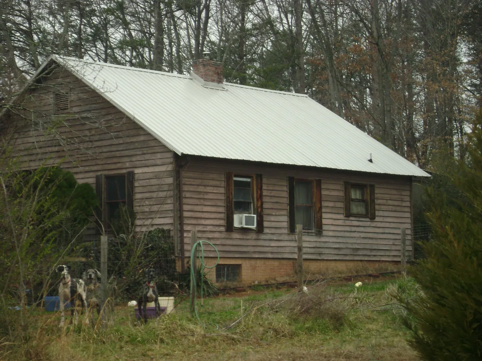White metal roof on an old wood sided farmhouse, from a Metal Roof Installation job in Coshocton